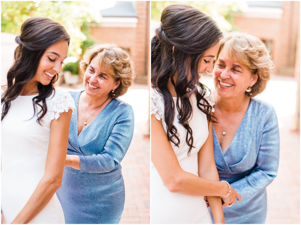 Mother helping daughter put on her wedding dress