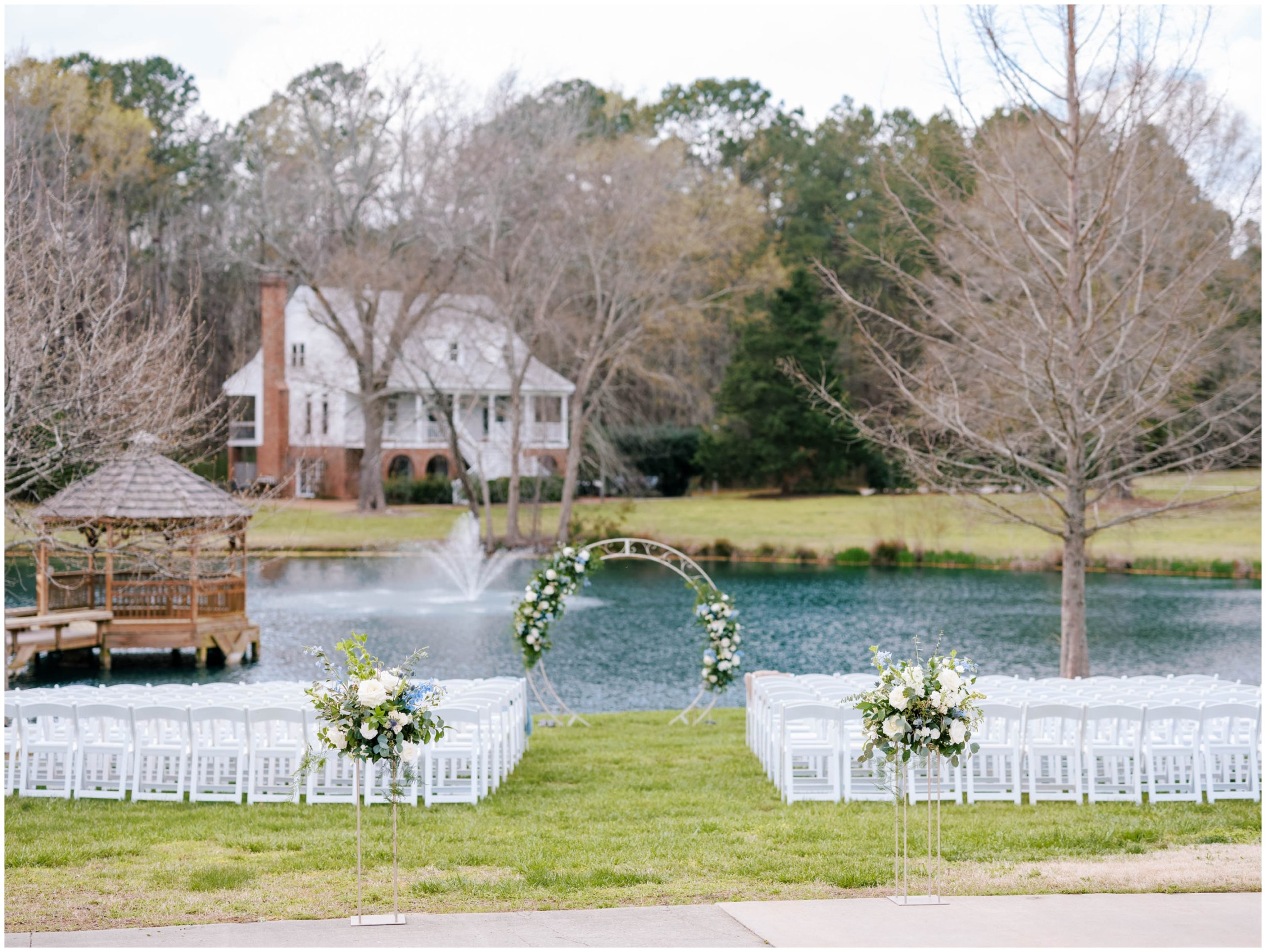 White chairs and an archway with blue and white florals for an outdoor spring wedding ceremony