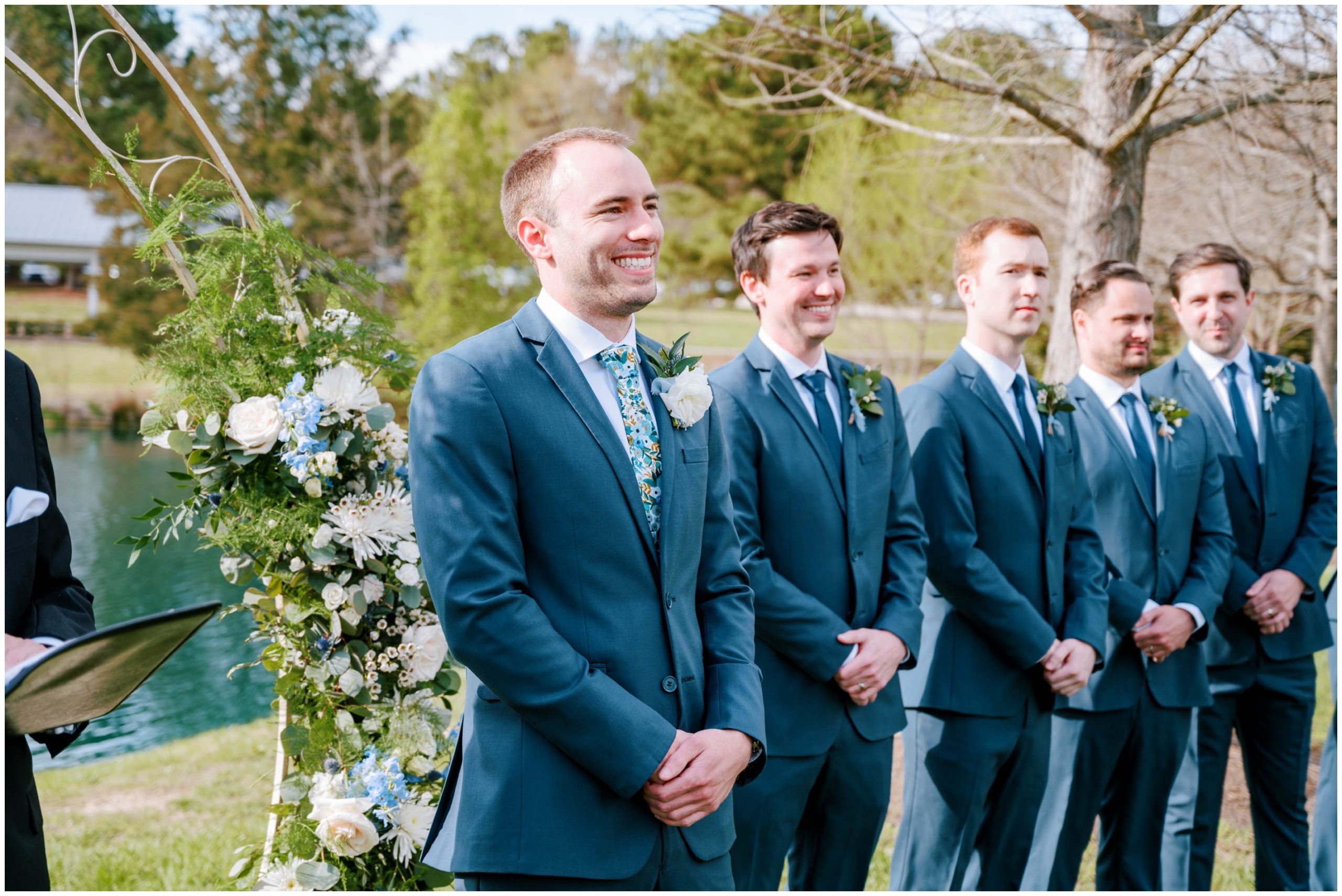 Groom in a dark blue suit with a floral necktie for a spring wedding