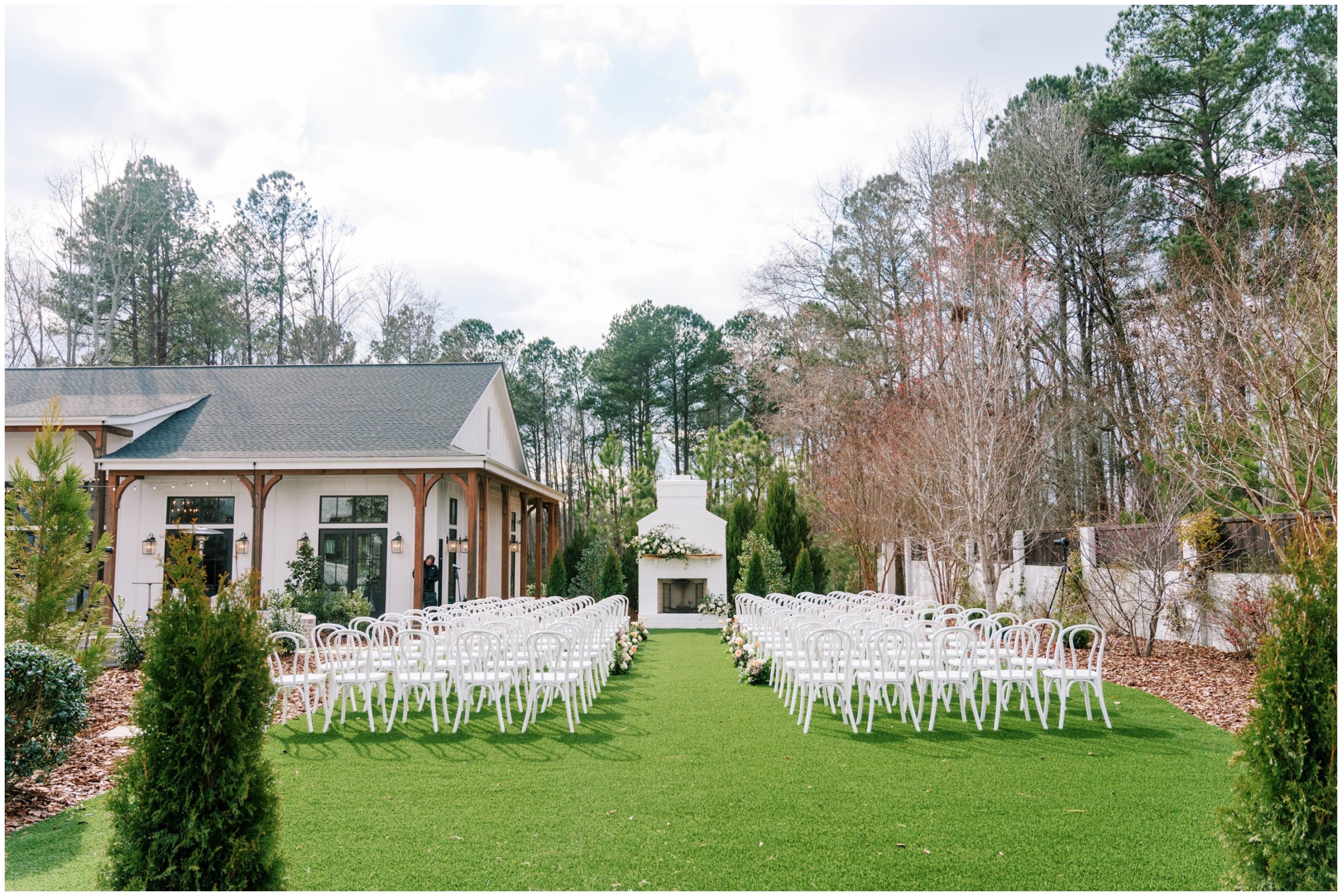 White cafe seating and white and peach florals for a spring outdoor wedding ceremony