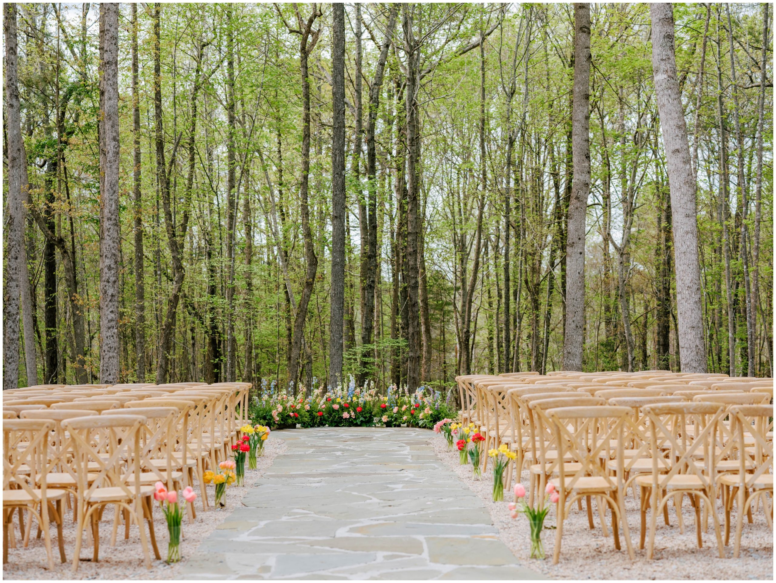 Wooden cafe chairs and pink, poppy red, periwinkle, and amber florals for a spring wedding ceremony