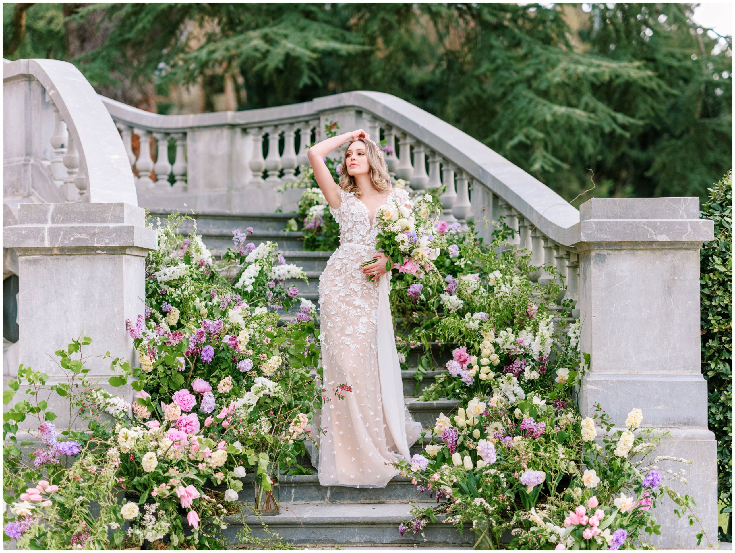Bride posing with pink, purple, and cream-colored flowers for a garden-inspired wedding