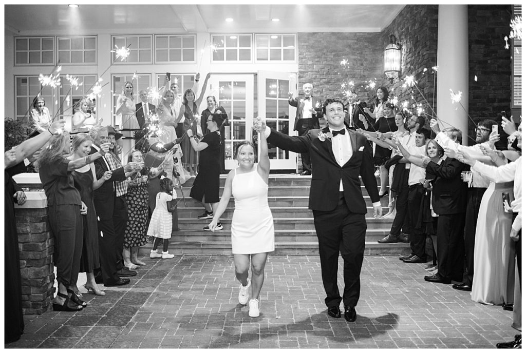 bride and groom make their exit with guest holding sparklers at the chapel hill country club