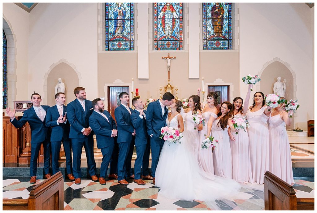 groomsmen and bridesmaids taking a picture with bride and groom