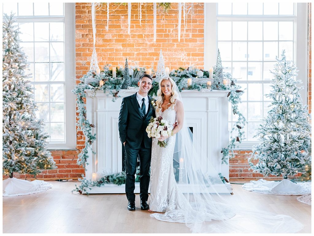 bride and groom in front of fireplace at the cotton room