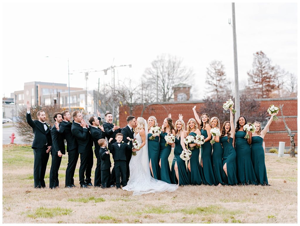 bridal party cheering for joy with the bride and groom at the cotton room