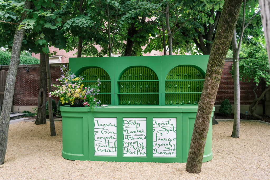 custom bar in green color blocking with wallpaper backing and signature cocktails written on the backing in the Meridian House