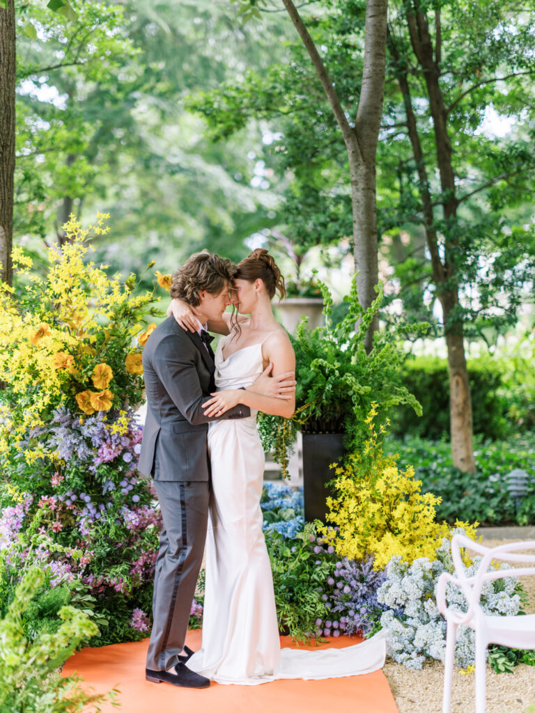 Bride and Groom at an outdoor ceremony with colorful florals and red aisle runner at the Meridian House in DC