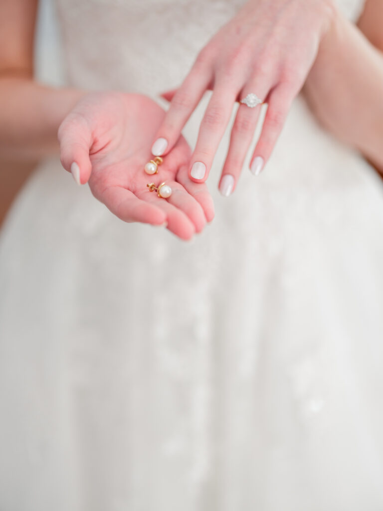 bride holding her earrings while getting ready for her wedding at Rose Hill Estate