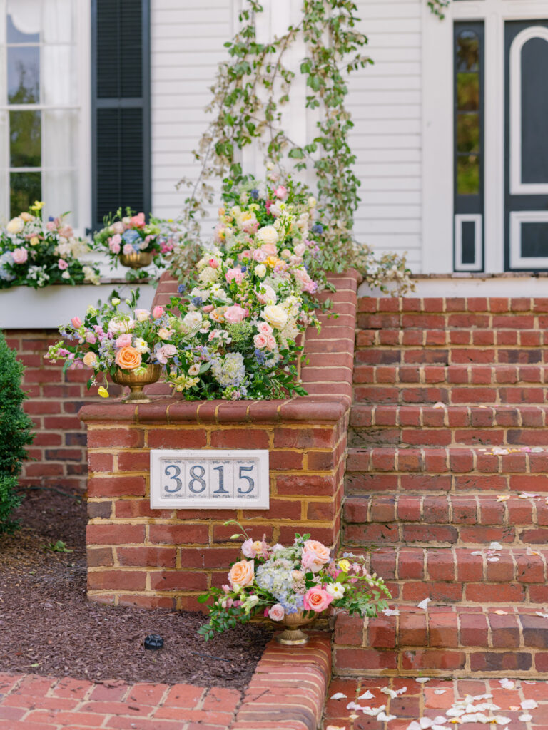 whimsical garden style multi colored florals for the ceremony on the front porch of Rose Hill Estate by Expression of Love Florist