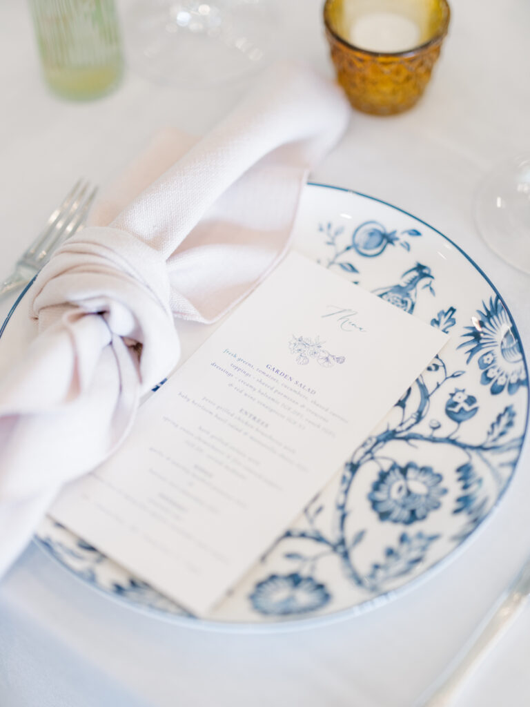 blue patterned plate with blush napkin and menu card for place settings at a wedding in Raleigh, NC
