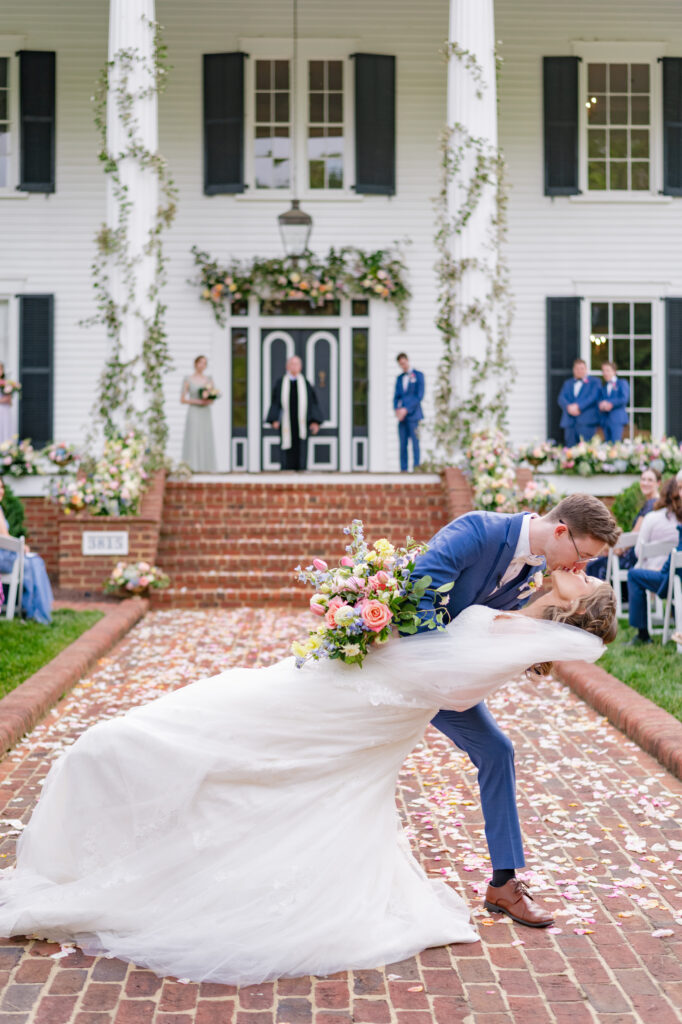 bride and groom kiss in the middle of the aisle with a dip at Rose Hill Estate