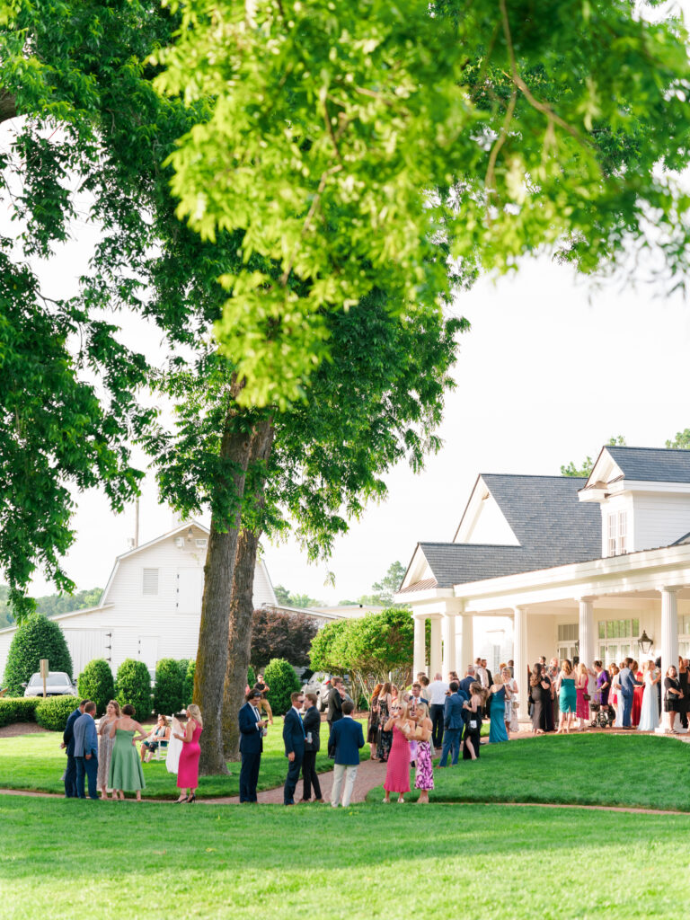 Guest mingle at the outdoor cocktail hour in June by the reception hall at Rose Hill Estate