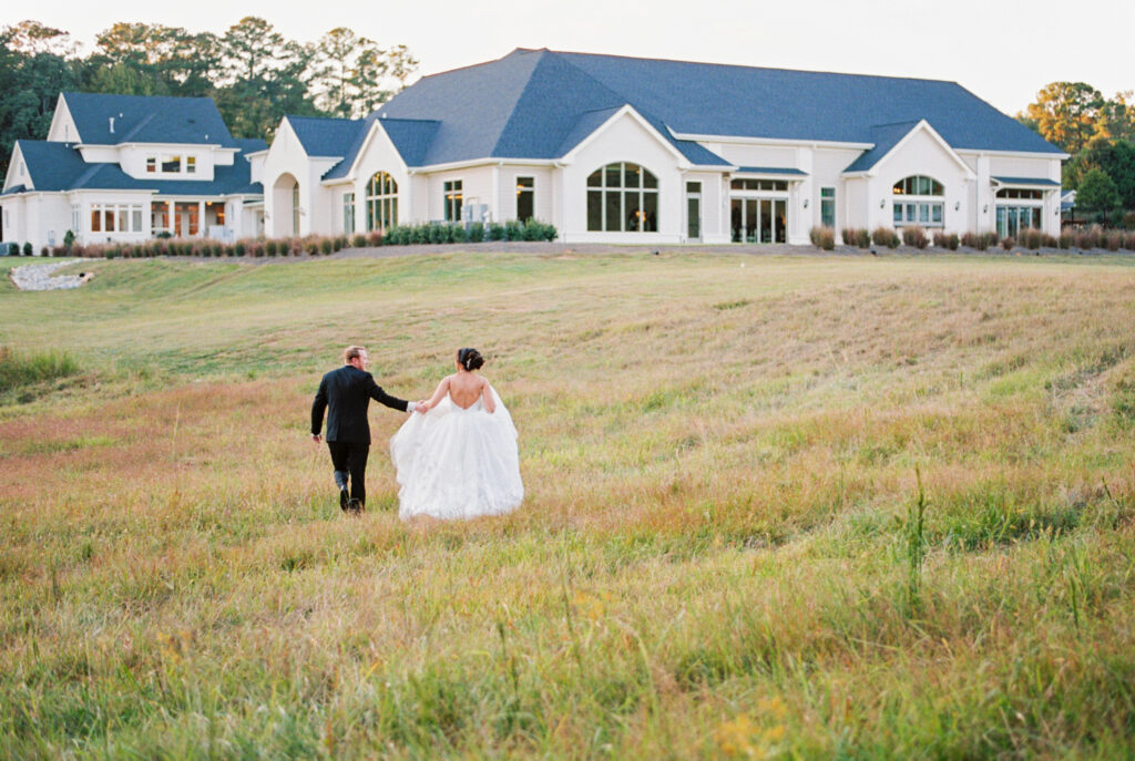 film golden hour photo of couple walking back to their reception at Donovan's Manor in Raleigh, NC